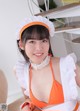 A woman in an orange and white maid outfit posing for the camera.